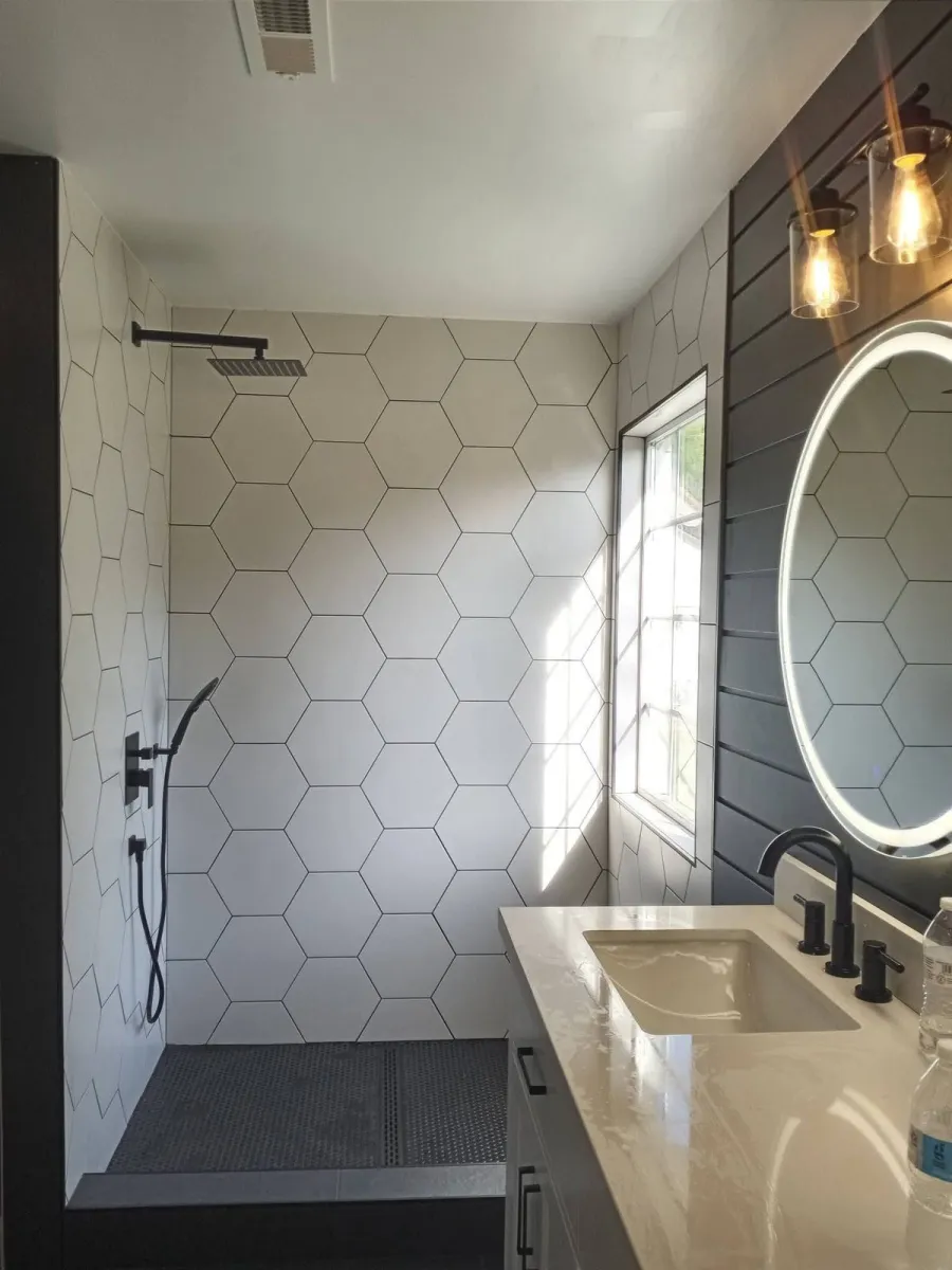 Renovated Charleswood bathroom with walk-in shower and round mirror