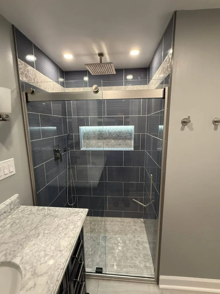 Renovated East Kildonan bathroom with dark tile shower and glass door
