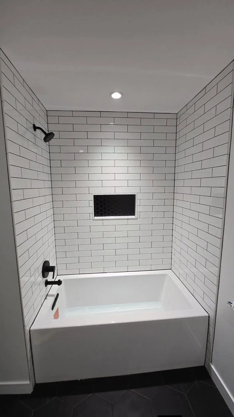 Renovated Fort Rouge bathroom with tiled tub surround and niche