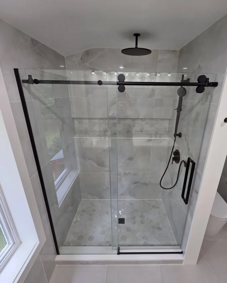 Renovated River Heights bathroom with a glass walk-in shower, rain head and handheld, and large-format marble-look porcelain tile