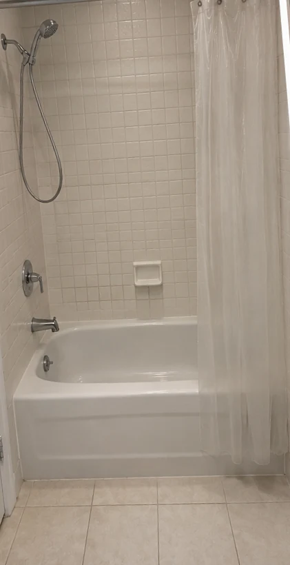Crescentwood bathroom before renovation, with the original bathtub and shower curtain