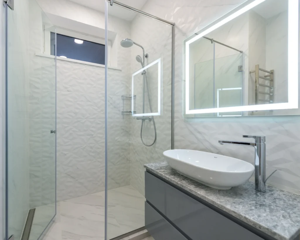 Modern bathroom design inspiration with a walk-in glass shower and illuminated mirror